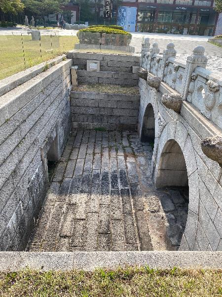 금천교(禁川橋) : 경희궁의 정문인 흥화문안에 흐르던 금천에 놓여 있던 다리로 1618년(광해군10)에 경희궁을 조성하면서 설치하였다. 금천교는 홍예교로 두 개의 아치로 구성되어 있다. 난간의 돌짐승이나 홍예 상이에 새겨진 도깨비 얼굴은 대궐바깥의 나쁜 기운이 궁궐 내로 들어오지 못하게 하는 상징적인 역할을 한다. 금천교는 일제강점기 때 이곳에 경성중학교가 설립되면서 땅에 묻혔으나 서울역사박물관 건립과 함께 발견된 옛 석조물을 바탕으로 2001년에 복원되었다(출처 : 서울역사박물관)